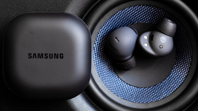The Galaxy Buds Pro 2 on a speaker next to their charging case.