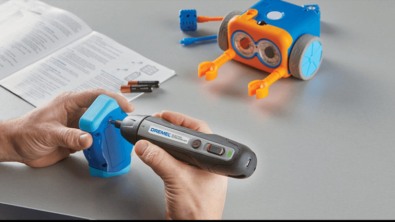 Using electric screwdriver on toy battery panel