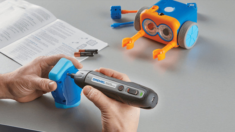 Using electric screwdriver on toy battery panel