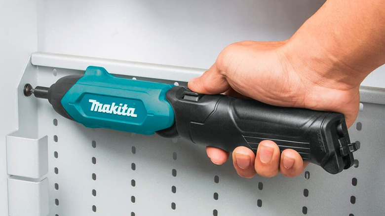 Using electric screwdriver on metal shelving