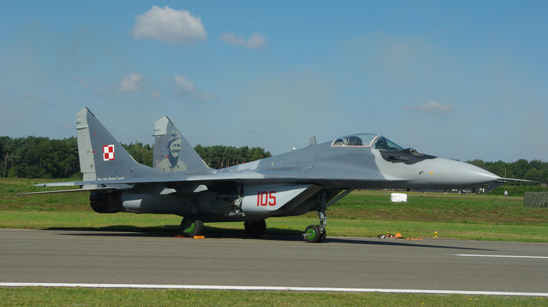 A Polish MiG 29 jet fighter about to take off from a runway, facing right