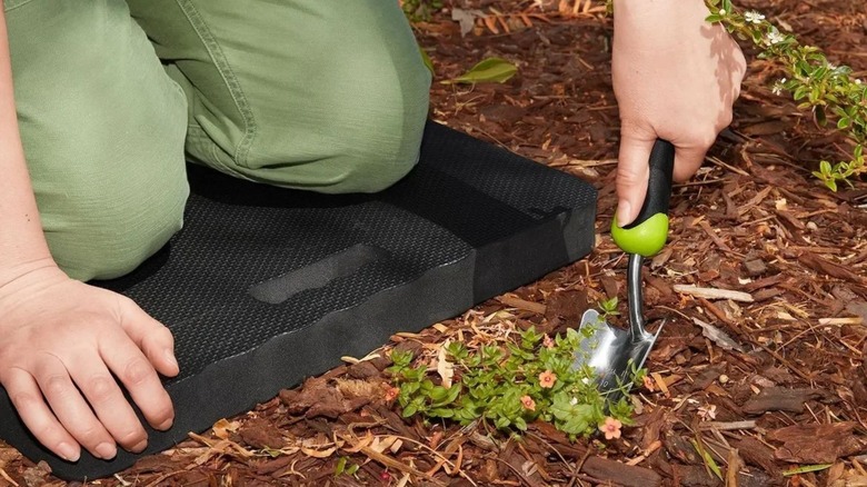 person using foam kneeling pad in garden