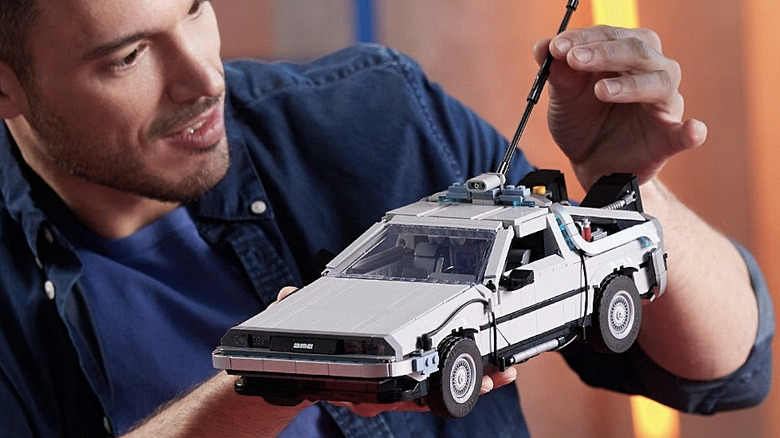 A man holding and admiring the Back to the Future Time Machine LEGO Icons set.