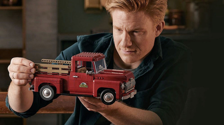 A man admiring the LEGO Icons Pickup Truck after building it.