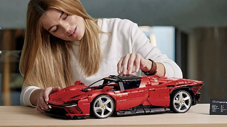 A woman building the LEGO Technic Ferrari Daytona SP3.