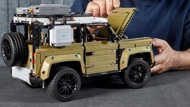 A man looking under the hood of the Land Rover Defender LEGO Technic set