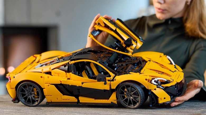 A woman admiring the McLaren P1 LEGO Technic set.