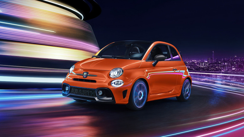 Fiat 500 Abarth cornering at speed during nighttime front 3/4 view