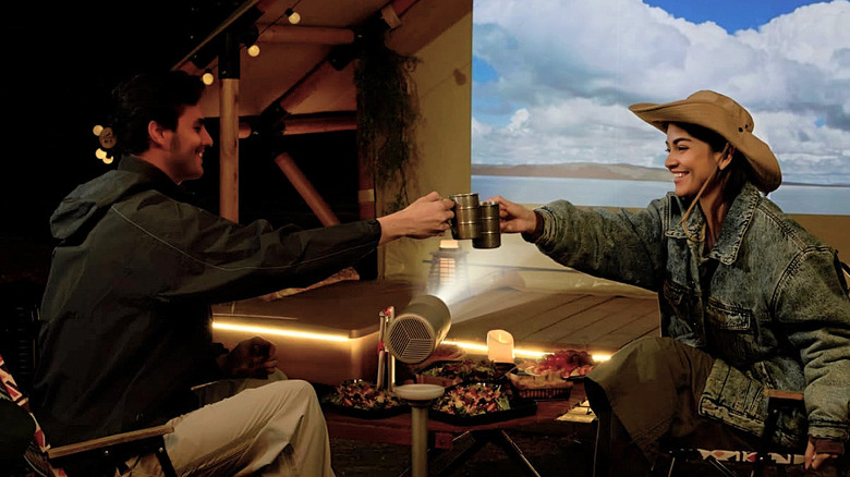 A couple using the Xgimi MoGo 4 projector outdoors.