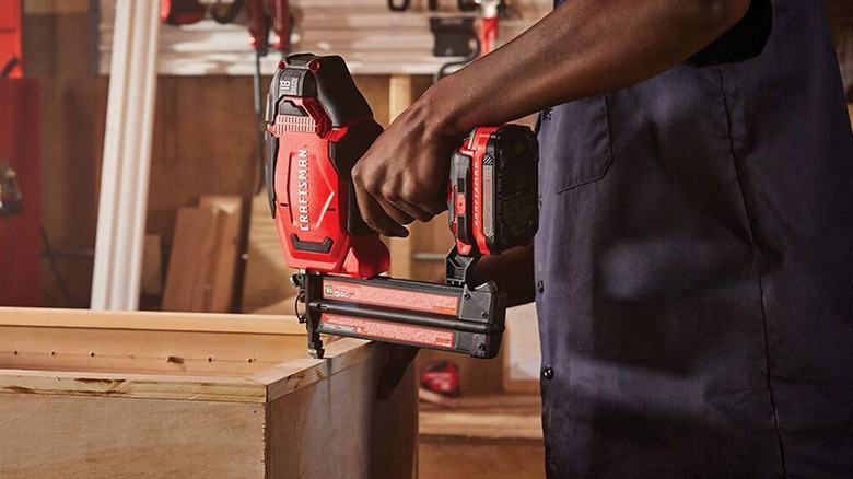 A man using a Craftsman Brad Nailer to nail two pieces of wood together