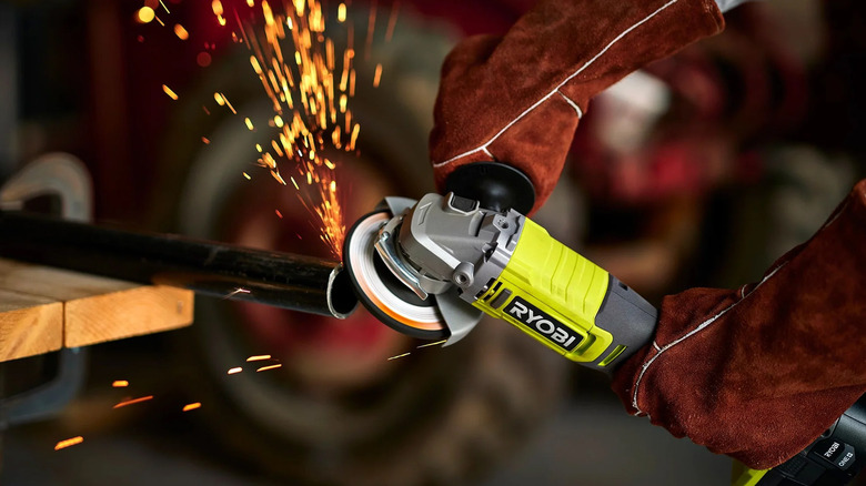 A person using a Ryobi angle grinder to smooth out the end of a pipe