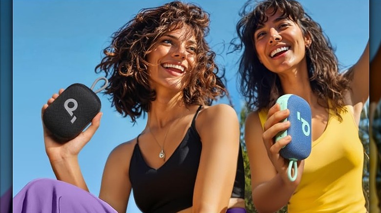 Two woman holding Soundcore Select 4 Go speakers in their hand.