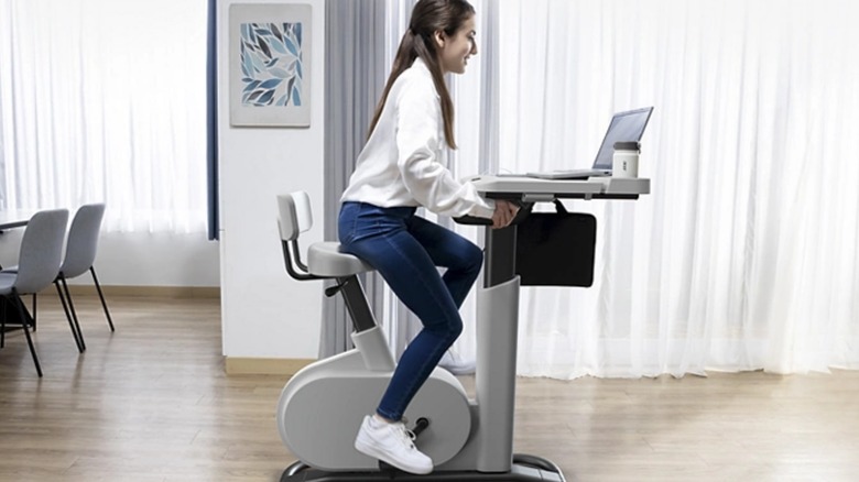 Woman on Acer eKinekt bike with laptop