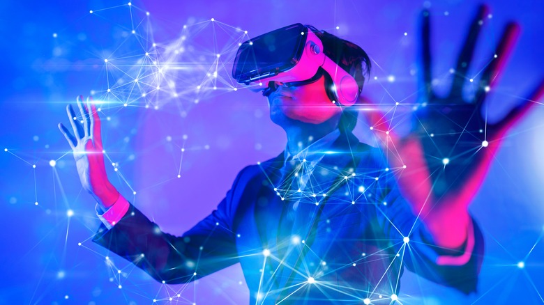 Male wearing VR goggles with blue tech background