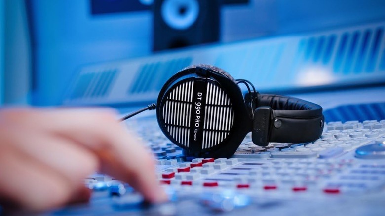 The Beyerdynamic DT 990 Pros resting on a mixing desk.