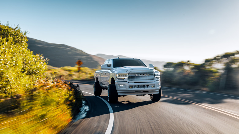 A white Dodge RAM taking a corner on a mountain road
