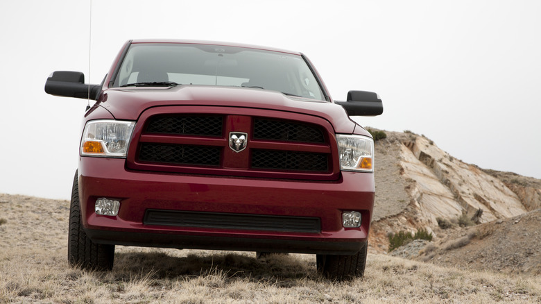 A 2012 Cherry red Dodge RAM 1500 coming down an incline, front view visible.