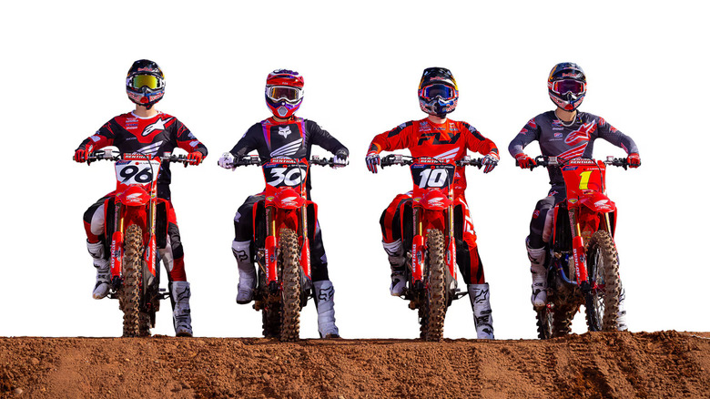 Four different riders on four different bikes from Honda's CRF line standing abreast on a dirt track.