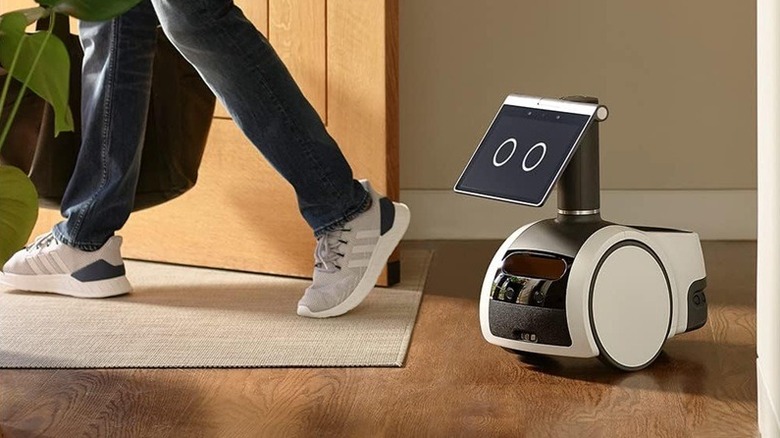 Amazon Astro robot following a person to the front door.