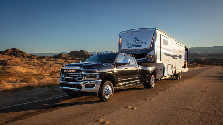 A blac 2025 Dodge RAM Heavy duty vehicle towing a massive live aboard caravan
