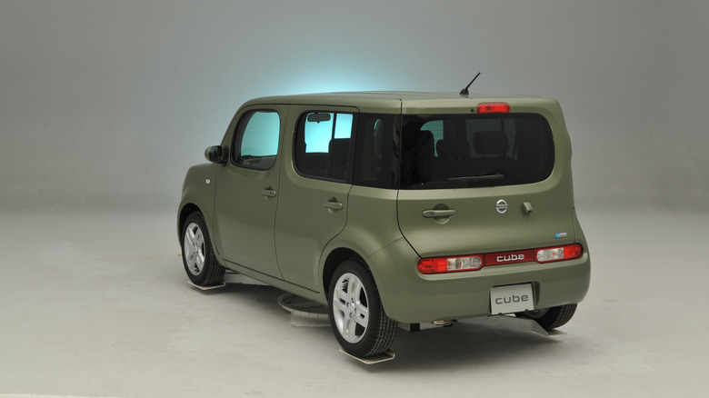 Green Nissan Cube on display and showing asymmetrical rear window and door