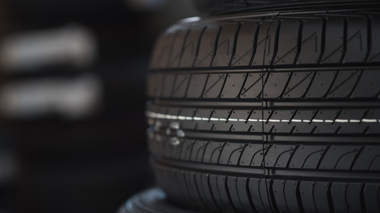 A brand new car tire stacked on another tire