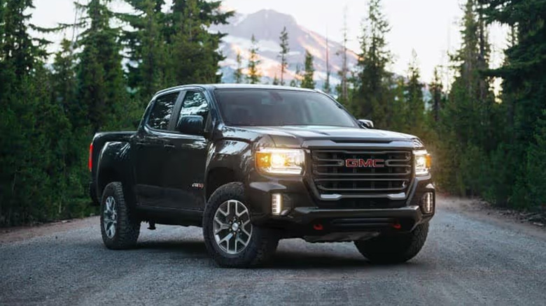 A GMC Canyon on a road in the woods