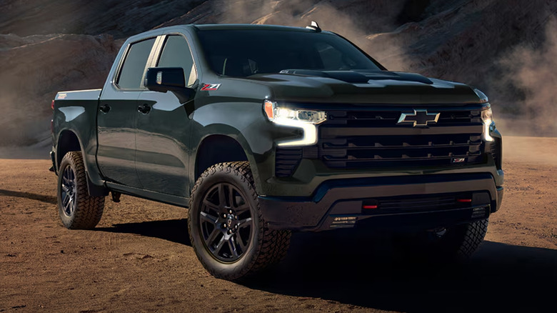 A dark colored Chevy Silverado driving on a desert