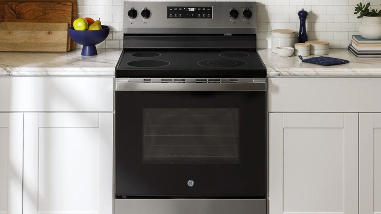 GE 30-Inch Electric Range between white cabinets