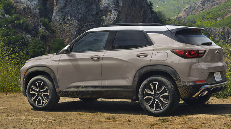 A 2026 Chevrolet trailblazer finished in metallic beige standing on arid grassland, with mountains in the back.