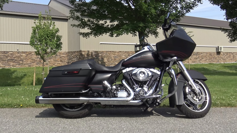 A black and silver 2009 Harley-Davidson Road Glide parked with its side profile visible at the edge of a street.