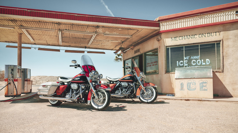 Two Harley-Davidson Electra Glide Highway King models parked next to each other outside an isolated gas station.