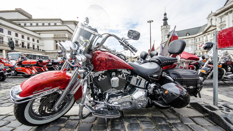 A red Harley-Davidson touring motorcycle with silver accenting parked in a town square in Poland during a rally.