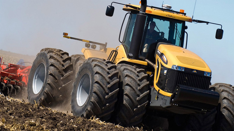 A yellow Challenger tractor plowing a field