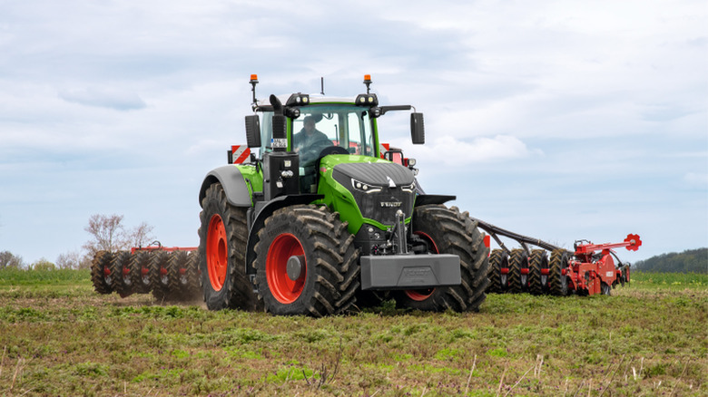 A Fendt 1000 Vario dragging a farm implement on a farm