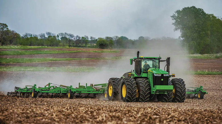 A John Deere 9R series tractor on a farm