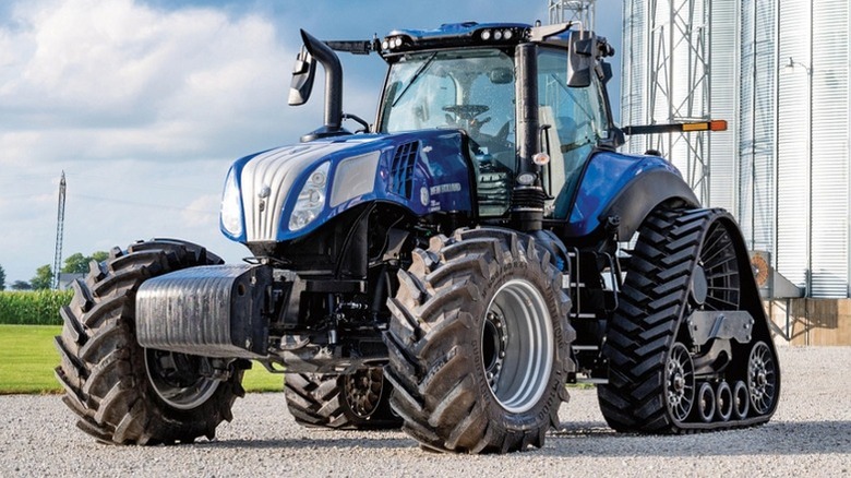 A blue New Holldan T8 riding on a farm