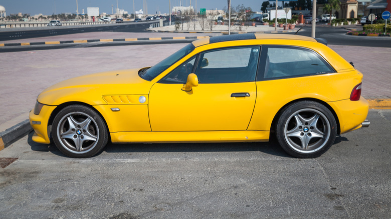 A yellow BMW Z3 M parked by a highway