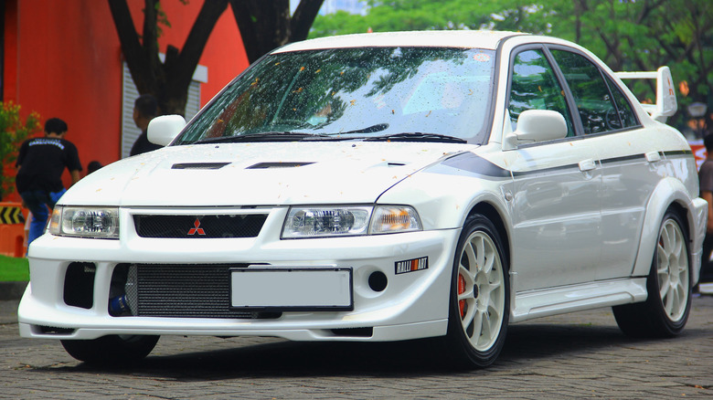 A white Mistubishi Evo 6 on display at a car show
