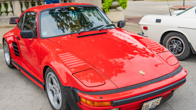 A red Porsche 930 Turbo at a vintage car display event