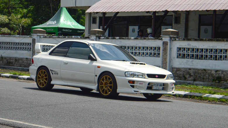 A white Subaru Impreza WRX with yellow rims