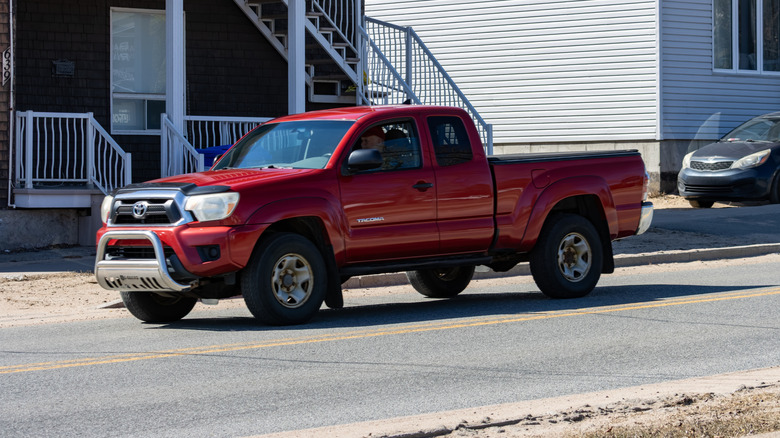 A red Toyota Tacoma parked in a suburb