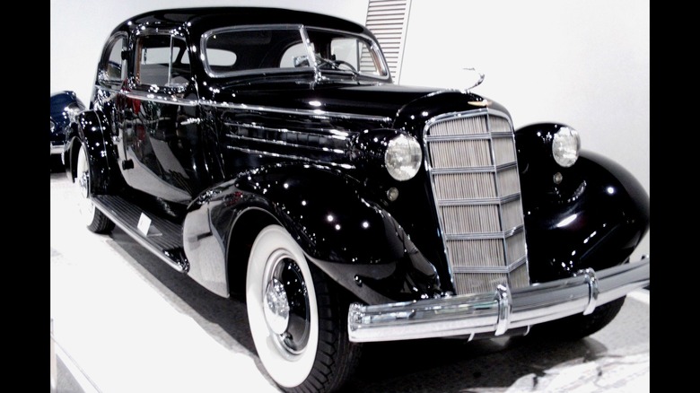 Black 1935 Cadillac V12 Aero Coupe Cadillac 370D Series 30 Fleetwood seen from front right quarter view on display indoors