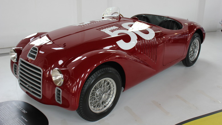 Red Ferrari 125 S seen from front left on display indoors