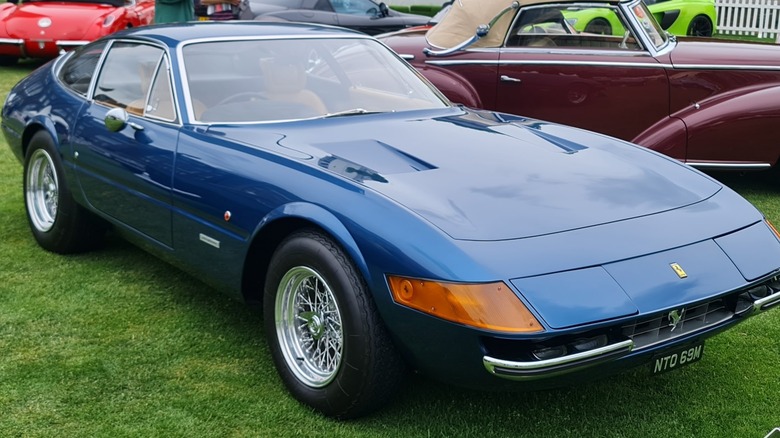 Blue Ferrari 365 GTB4 "Daytona" coupe seen from front right on display outdoors at London Concours 2022