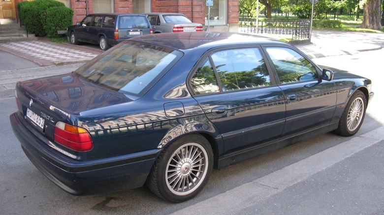 Dark blue BMW 750iL seen from right rear parked on street