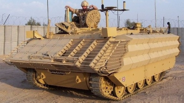 A British FV432 parked on sand in the desert.