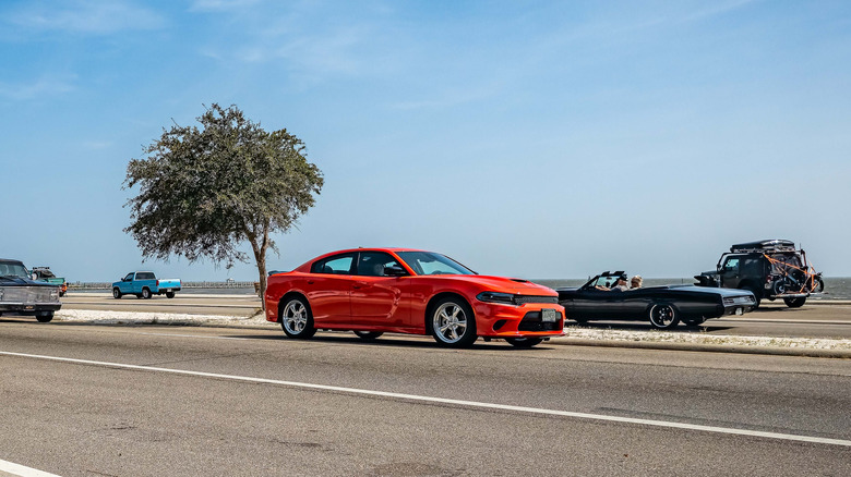 The front right quarter view of a red 2021 Dodge Charger four-door sedan in a parking lot.