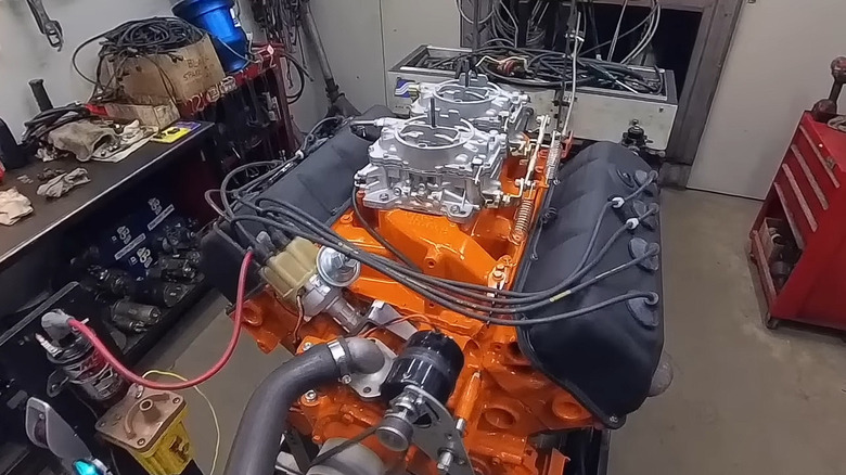 An orange 528 Hemi by Mopar drop-in crate engine on a garage workbench.