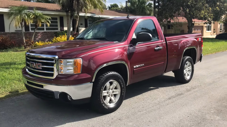 A side shot of a red 2013 GMC Sierra parked
